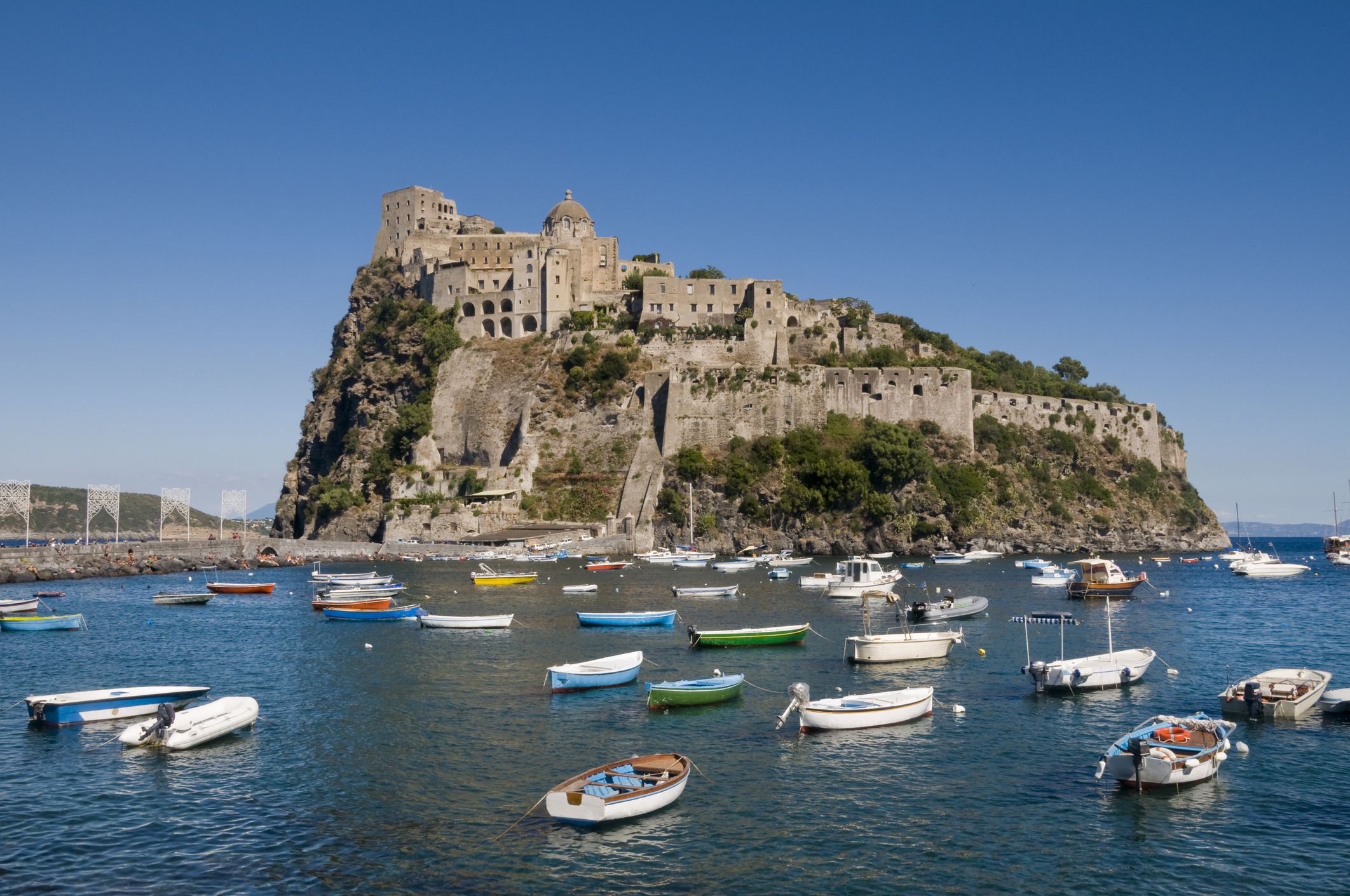 "Castello Aragonese in Ischia Ponte, on Ischia island near Naples, Italy. Many little boats in the sea."
